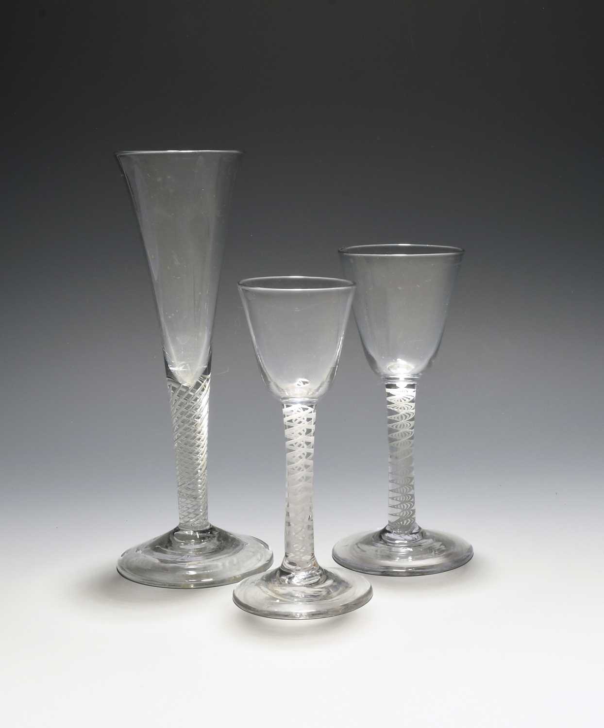 Two wine glasses and an ale flute, c.1750-60, the wines with round funnel bowls on multiseries