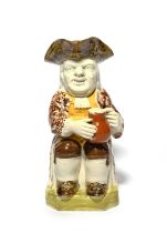 A Wood type Toby jug, c.1790-1800, seated with a jug of ale and a long-stemmed clay pipe, his coat