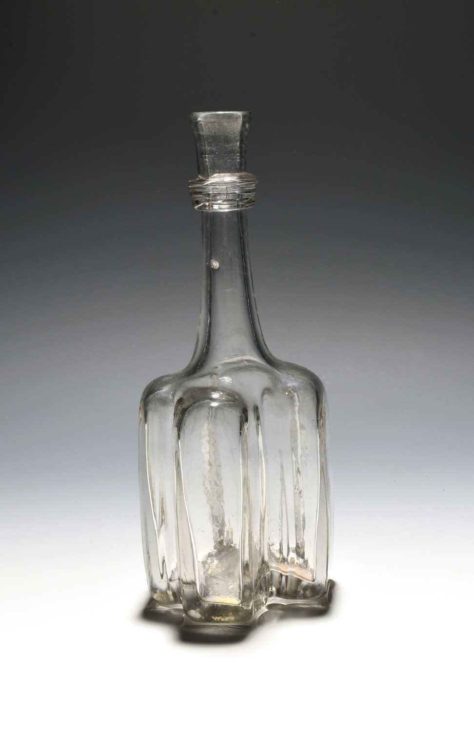 A heavy cruciform glass serving bottle or decanter, c.1740, the body of strong cross shape, the