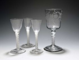 Three wine glasses and a goblet, c.1760, the wine glasses with round funnel bowls, raised on multi-