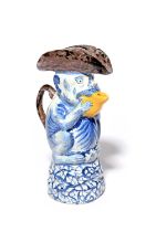A Delft comical monkey jug and cover, mid 18th century, modelled as a monkey holding a fruit up to