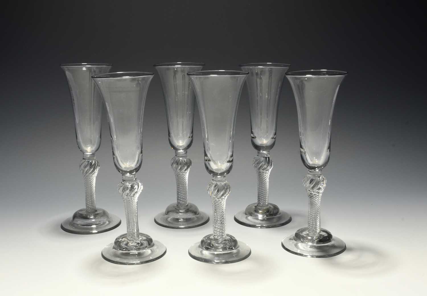 A set of six ale glasses, c.1750, with slender bell bowls raised on shoulder-knopped airtwist