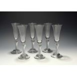 A set of six ale glasses, c.1750, with slender bell bowls raised on shoulder-knopped airtwist