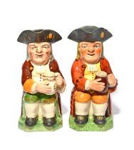 Two Ordinary Toby jugs, c.1820, each holding a foaming jug of ale on one knee, wearing a red coat