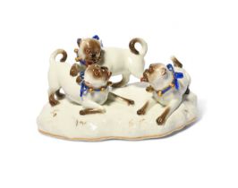 A Meissen group of pugs at play, 19th century, the three dogs wearing blue ribbon collars with