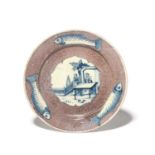 A delftware plate, c.1750, the well finely painted in blue with a Chinese dignitary seated at a