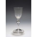 A balustroid wine glass, c.1730-40, the generous round funnel bowl with honeycomb moulding to the