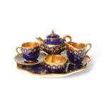 A Coalport miniature solitaire tea service, 1st half 20th century, decorated with gilt designs on