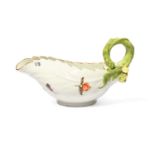 A Meissen leaf-moulded sauceboat, c.1740, formed of overlapping cos leaves, painted with Holzschnitt