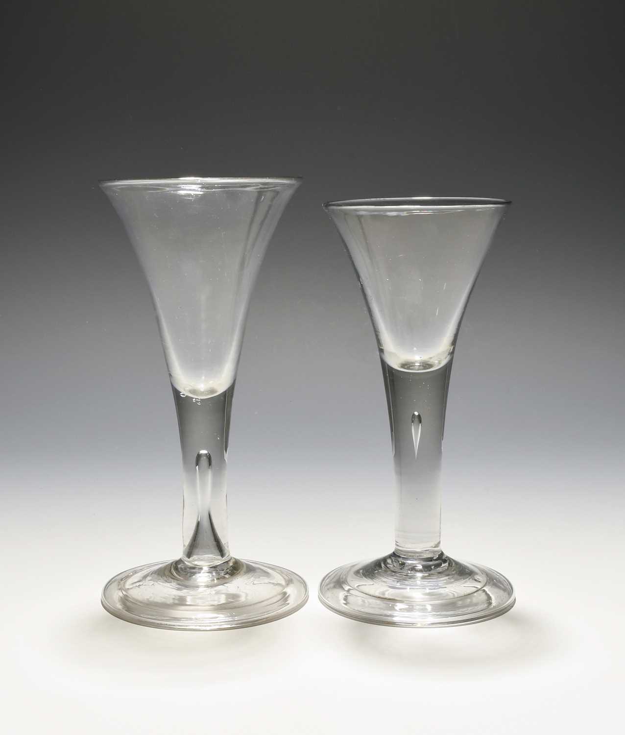 Two wine glasses, c.1740-50, with drawn trumpet bowls rising from plain teared stems over folded
