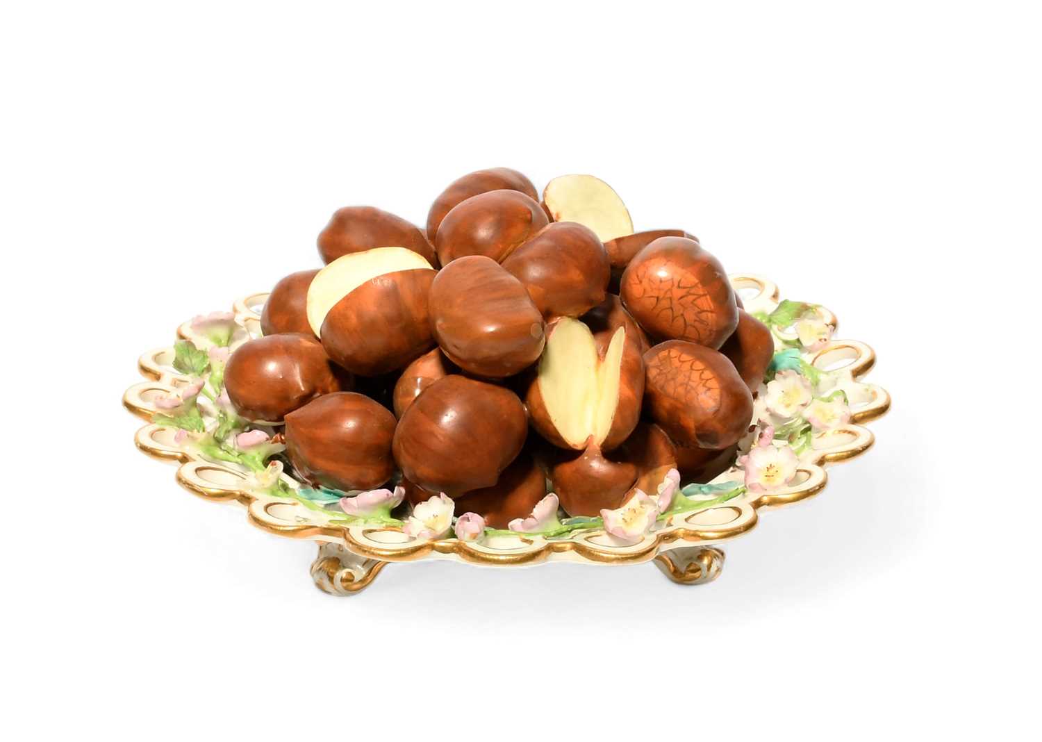 A Minton trompe l'oeil plate, c.1830, the well piled with sweet chestnuts, the spectacle rim applied