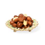 A Minton trompe l'oeil plate, c.1830, the well piled with sweet chestnuts, the spectacle rim applied