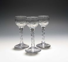 Three small wine glasses, c.1770, the rounded bowls engraved with polished swags over cut designs,