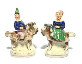 A pair of Staffordshire porcelain figures of Punch and Judy, 19th century, the grotesque couple