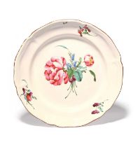 A large French faïence plate or charger, late 18th century, boldly painted with a flower spray, with