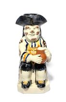 An Ordinary Toby jug and stopper, c.1800, seated with a foaming jug of ale and a long-stemmed