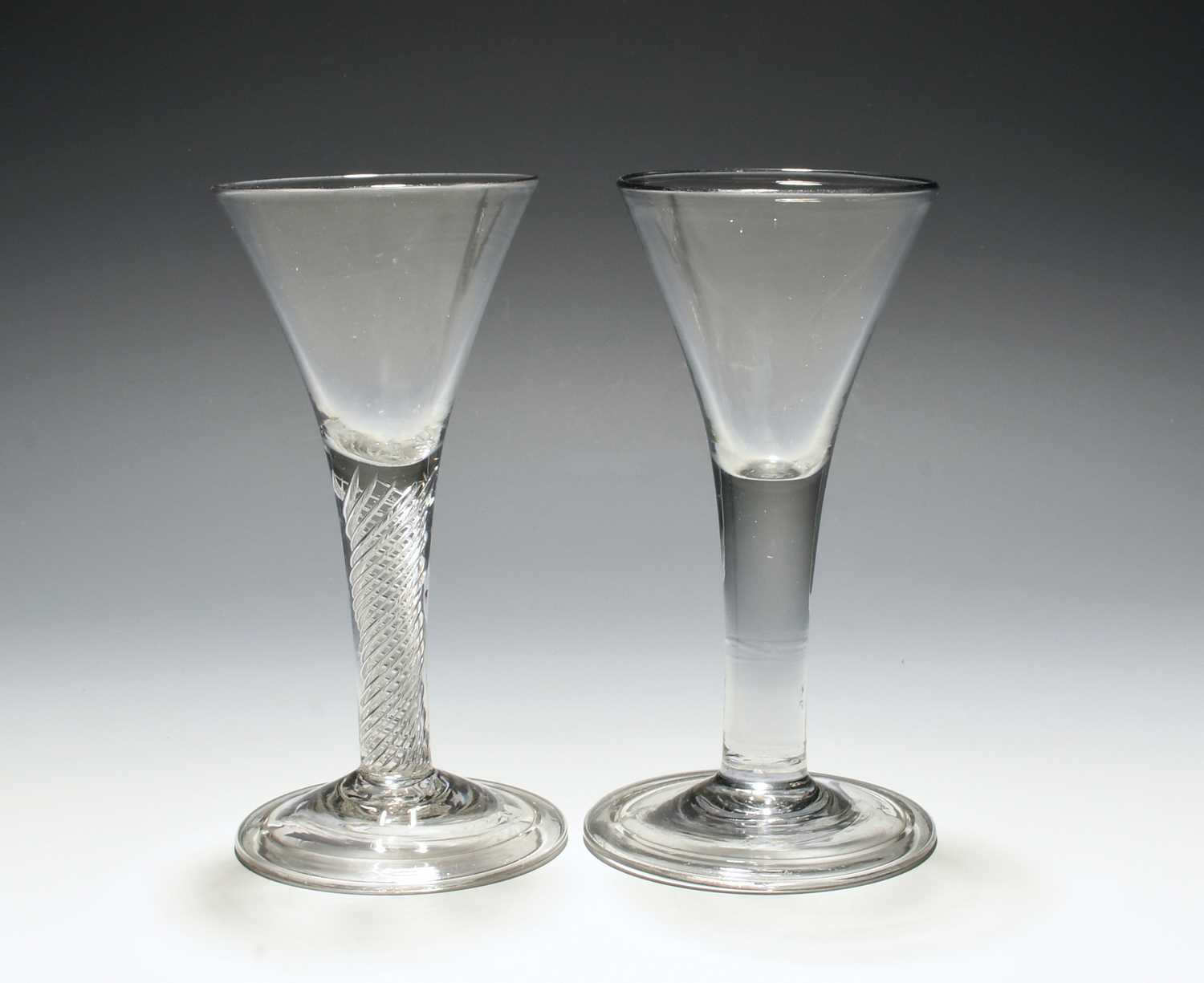 Two wine glasses, c.1740-50, with drawn trumpet bowls, one over a dense airtwist stem, the other