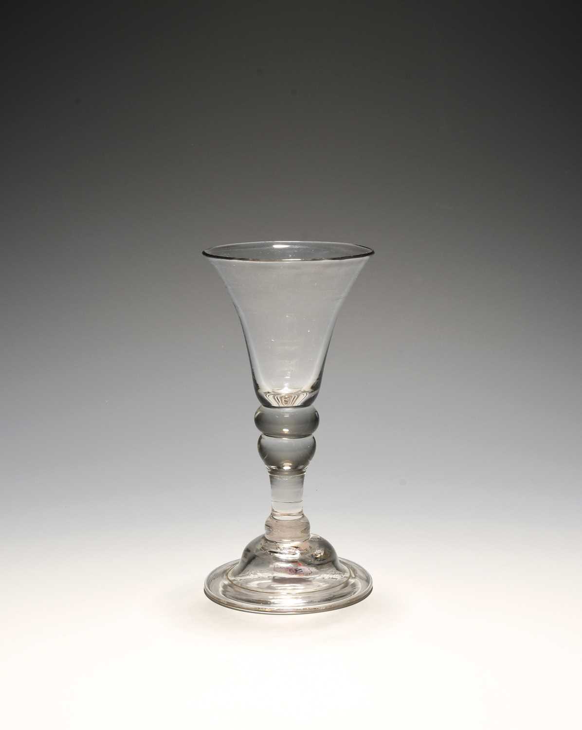 A small baluster wine glass, c.1730, with a bell bowl over a cushion knop and inverted baluster