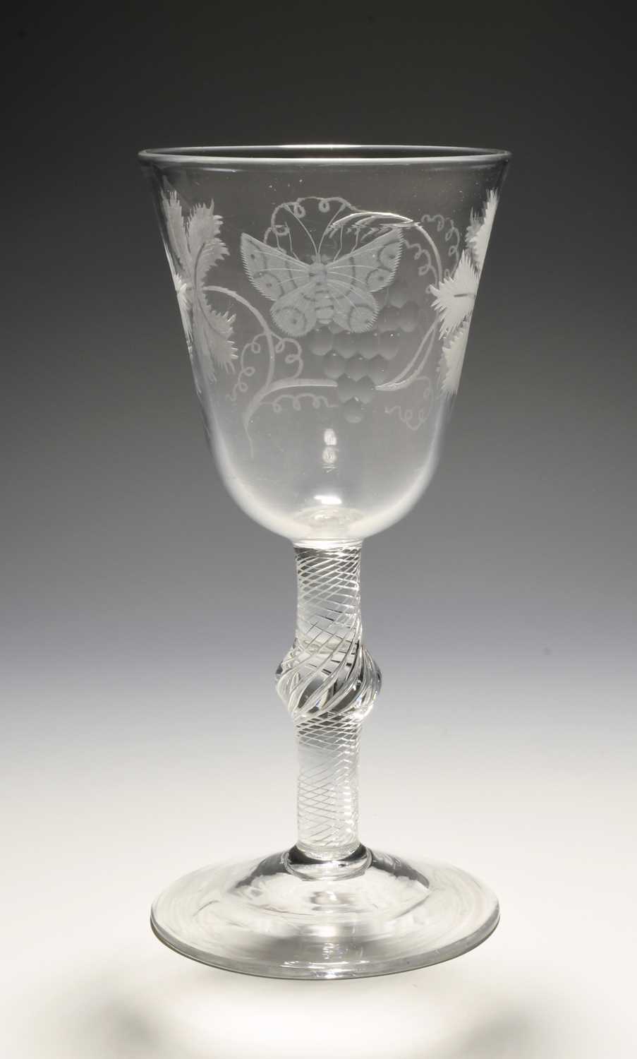 A large glass goblet, c.1760, the round funnel bowl engraved with a butterfly and a large bunch of