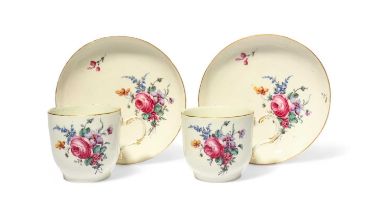 A pair of Tournai coffee cups and saucers, c.1775, finely painted with sprays of flowers including