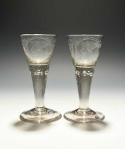 A pair of Bohemian wine glasses, dated 1796, the drawn trumpet bowls engraved with a profile