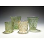 Four German waldglas beakers, 15th century, three of a pale green tone, with wrythen moulding and