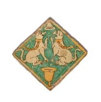 An Italian maiolica floor tile, 17th century, painted in the Pesaro manner with two dogs facing each