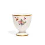 A Lille porcelain egg cup, late 18th century, the small U-shaped form painted with small flower
