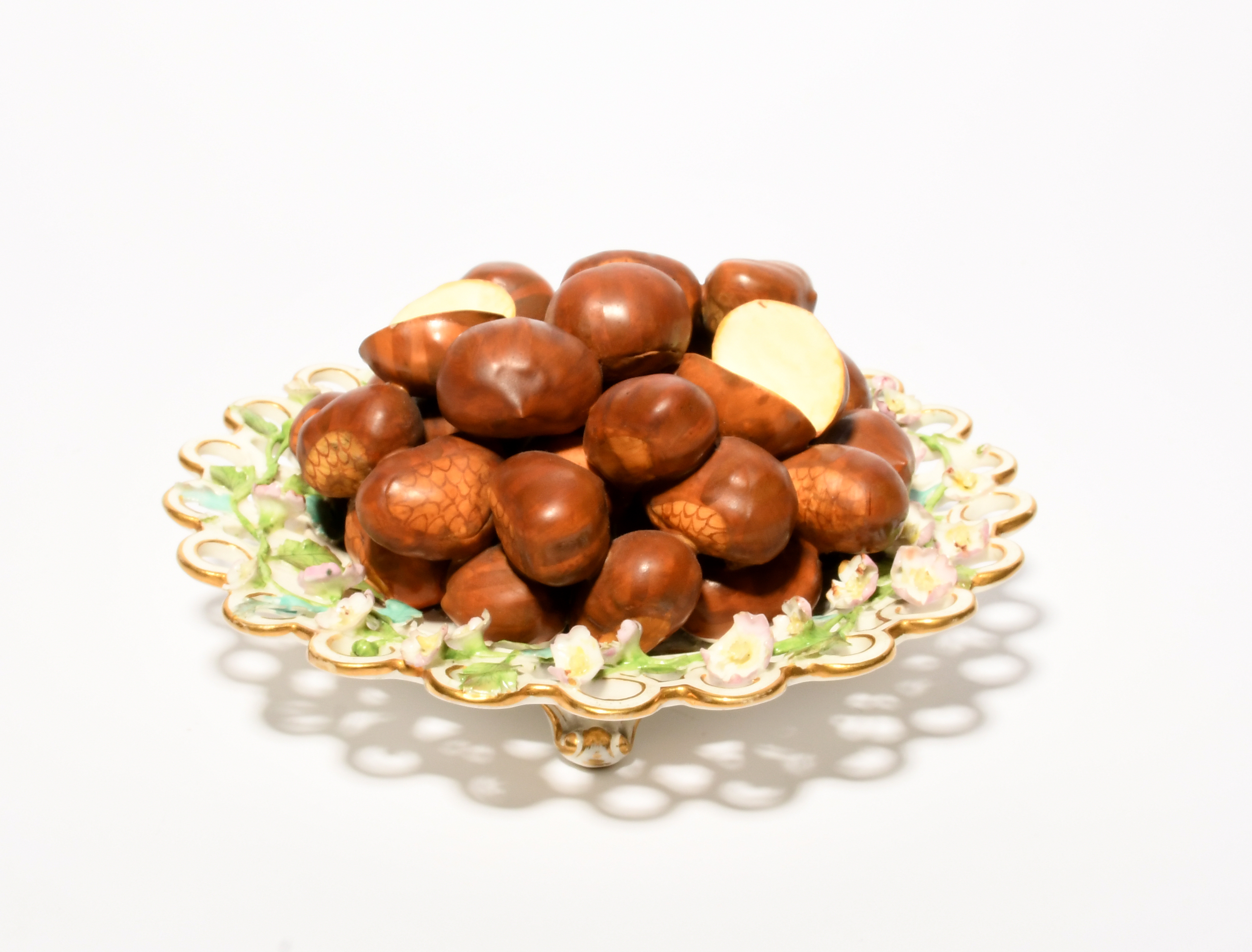 A Minton trompe l'oeil plate, c.1830, the well piled with sweet chestnuts, the spectacle rim applied - Image 2 of 2