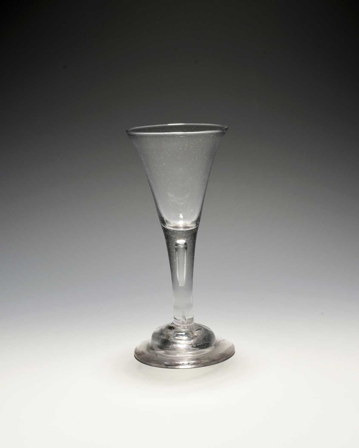 A wine glass, c.1720-30, the drawn trumpet bowl raised on a plain stem enclosing a long tear over