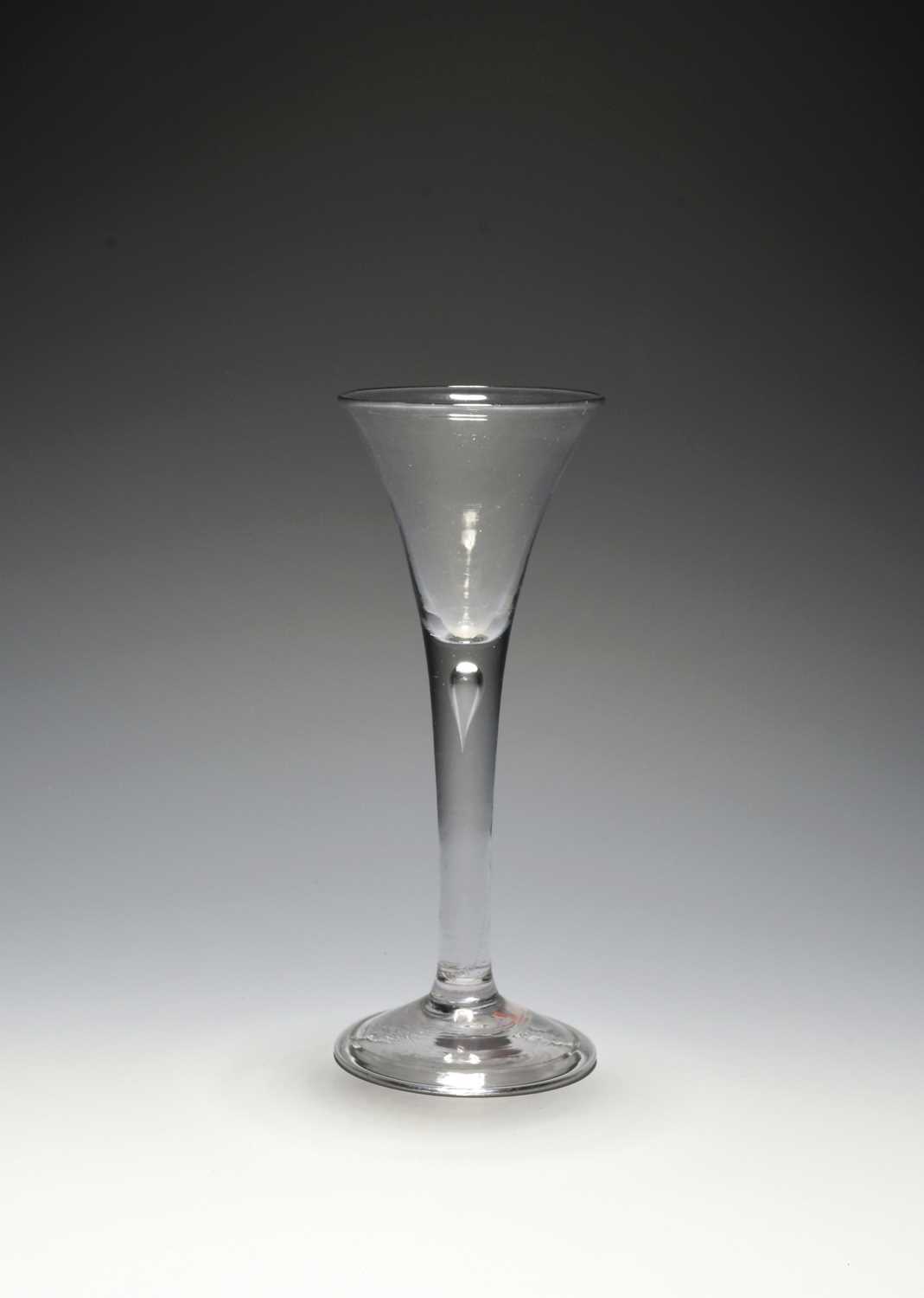 A small wine glass, c.1730, the drawn trumpet bowl raised on a slender plain stem enclosing a single