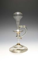 A French glass lacemaker's lamp, 17th century, the hollow stem rising to a swollen knop over a domed