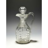 A cut glass claret jug and stopper, early 19th century, cut with vertical bands of polished circles,