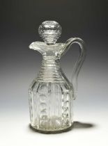 A cut glass claret jug and stopper, early 19th century, cut with vertical bands of polished circles,