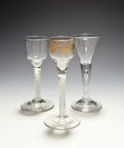 Three small wine glasses, c.1750-70, two with ogee bowls, one gilded with grapevine, both raised