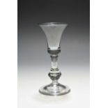 A baluster wine glass, c.1720, the bell bowl with a solid base, raised above a drop knop stem and