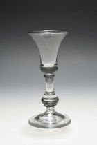 A baluster wine glass, c.1720, the bell bowl with a solid base, raised above a drop knop stem and