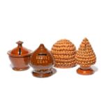 Four small Sussex slipware money boxes, 19th century, two modelled as pinecones with alternating