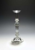 A tall pedestal glass candlestick, c.1720, the moulded sconce with everted rim, raised on a pedestal