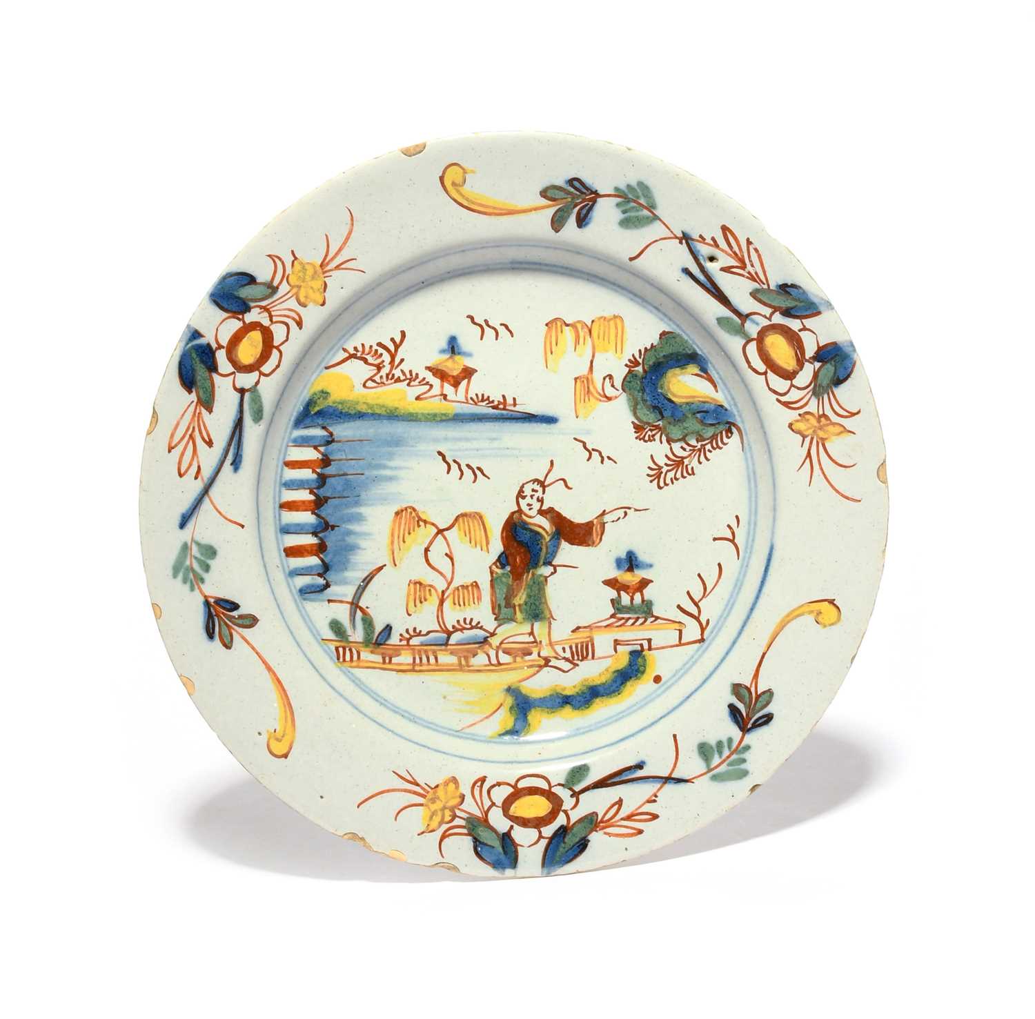 A Delft plate, c.1730, brightly painted in red, yellow, blue and green with a Chinese man crossing a