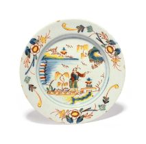 A Delft plate, c.1730, brightly painted in red, yellow, blue and green with a Chinese man crossing a