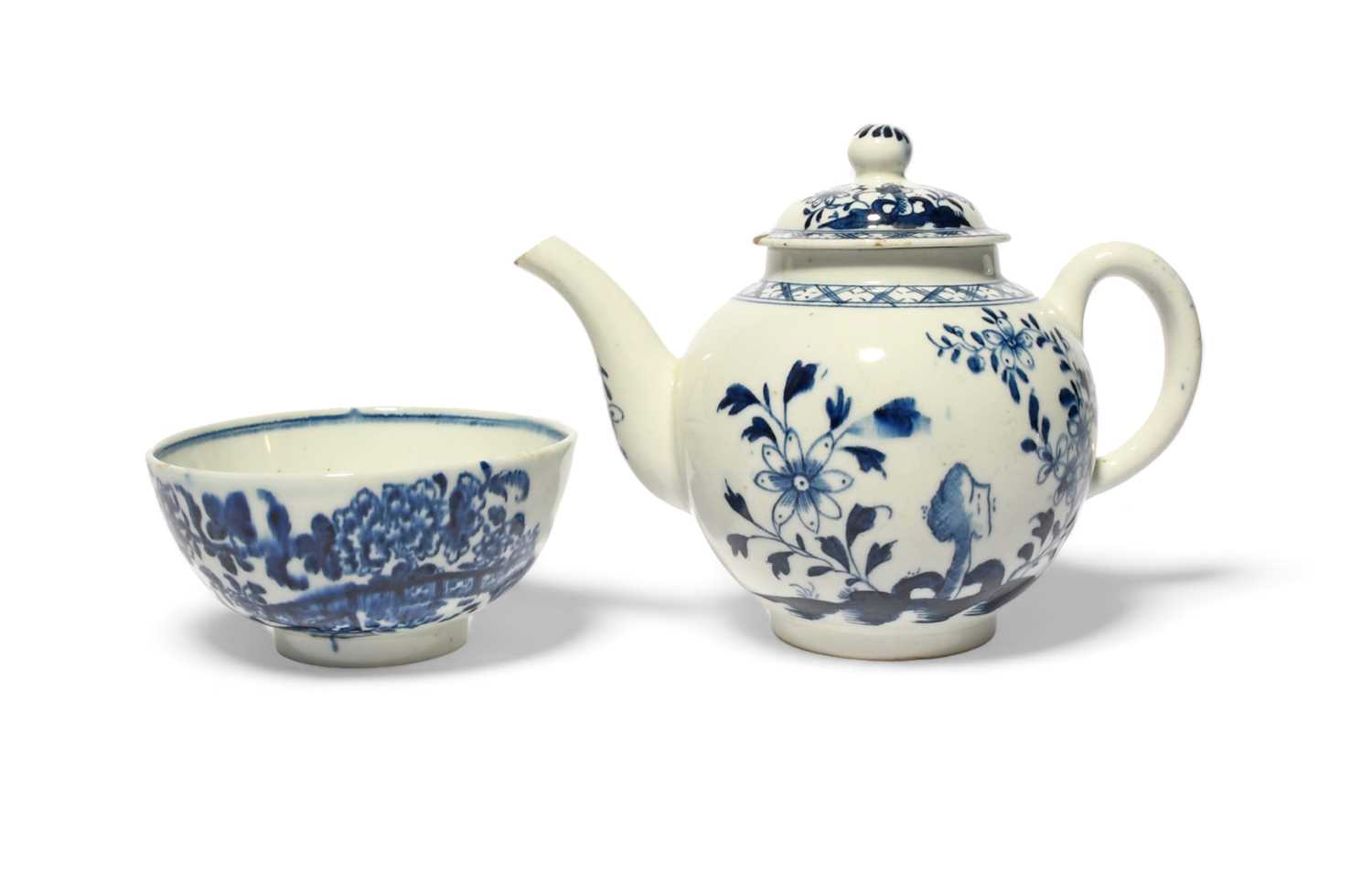 A Lowestoft blue and white teapot and cover, c. 1765-70, painted with flowers emerging from holey