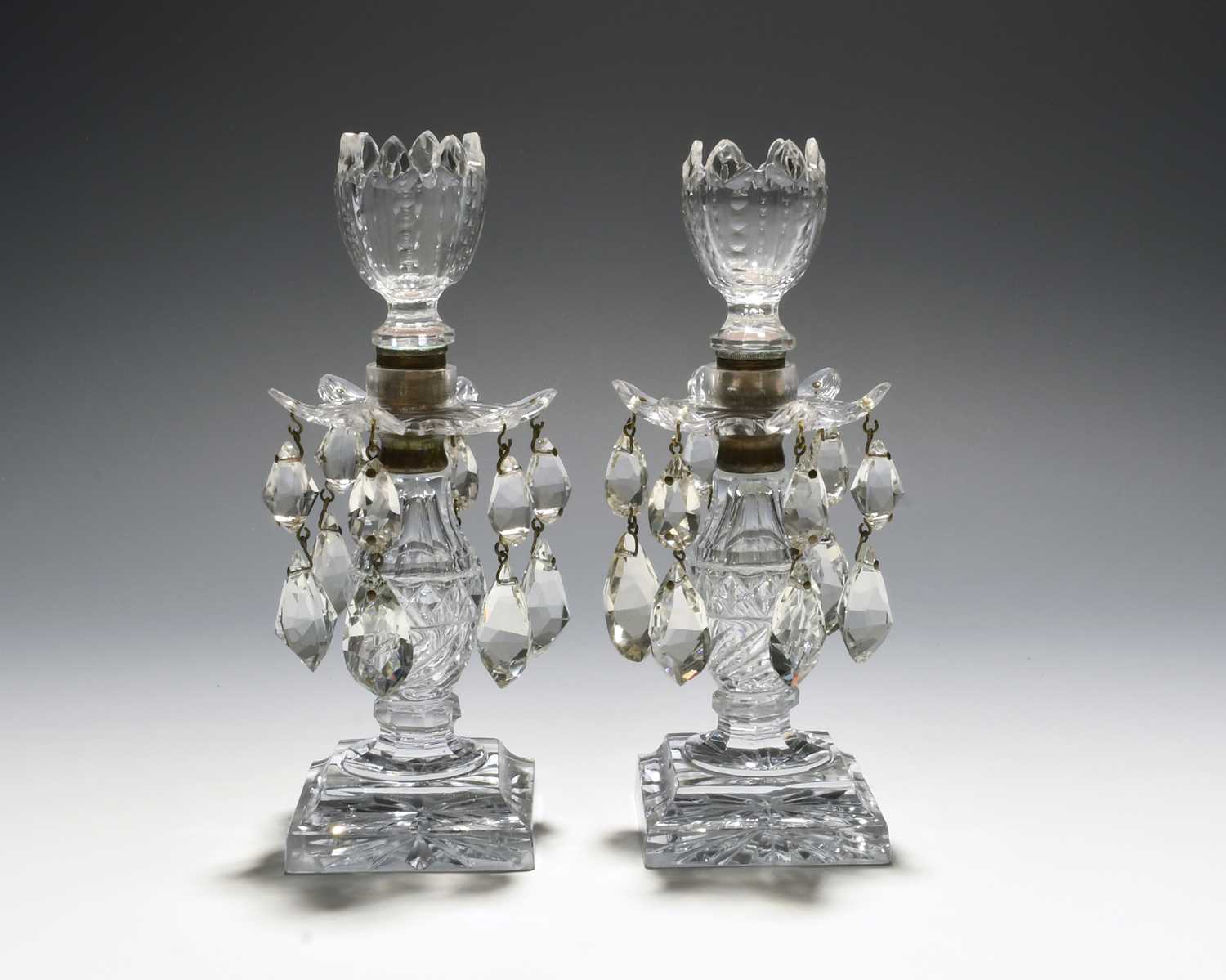 A small pair of cut glass lustre candlesticks, early 19th century, the six-petalled drip pans hung