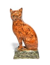 A rare pearlware figure of a cat, early 19th century, seated on its haunches with head turned to the