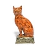 A rare pearlware figure of a cat, early 19th century, seated on its haunches with head turned to the