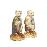 A pair of Staffordshire pearlware figures of monkeys, 19th century, each seated on a low rocky