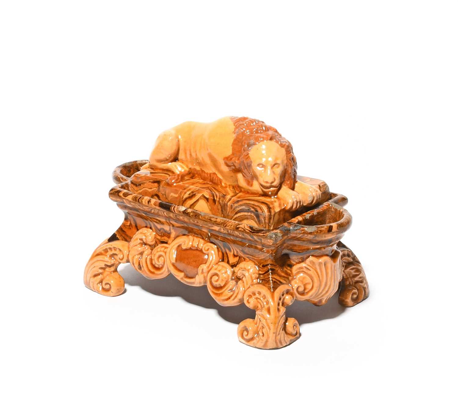 A slipware double inkwell, 19th century, the cover modelled with a recumbent lion, the rectangular