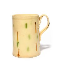 A creamware mug, c.1780, of Whieldon type, the cylindrical form decorated with small drips of
