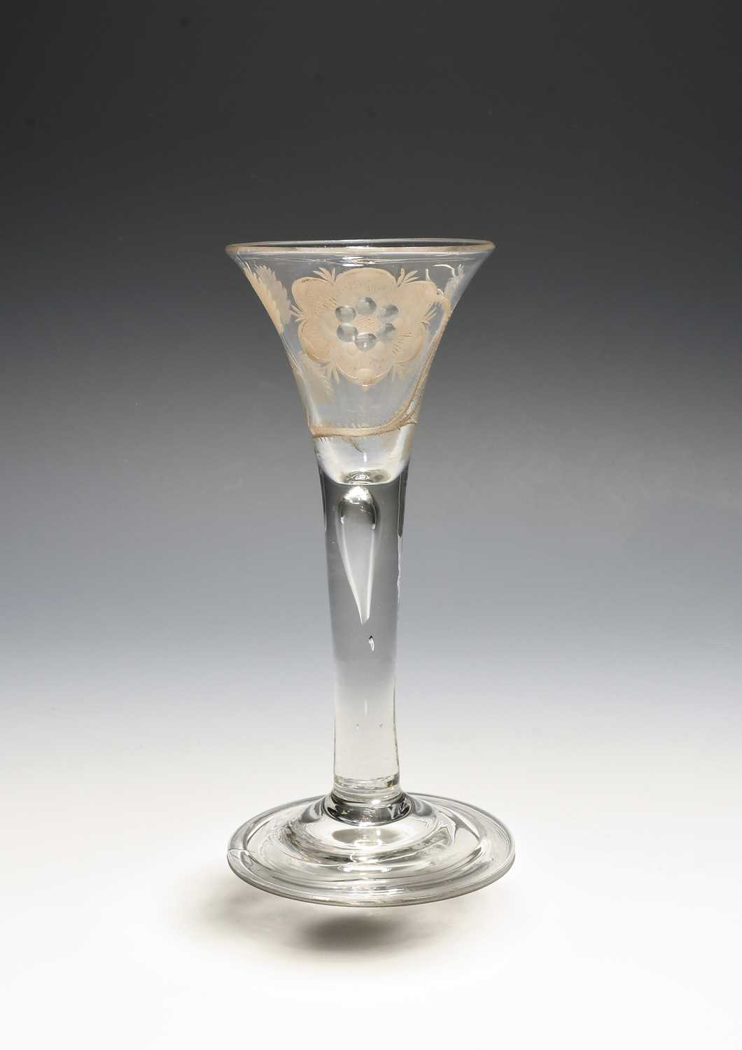 A Jacobite wine glass, c.1750, the drawn trumpet bowl engraved with a large rose and bud spray