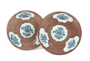 A pair of Wincanton delftware plates, c.1760, painted with three shaped panels of stylised flower